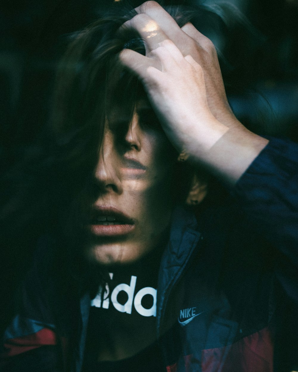 man in blue jacket covering his face