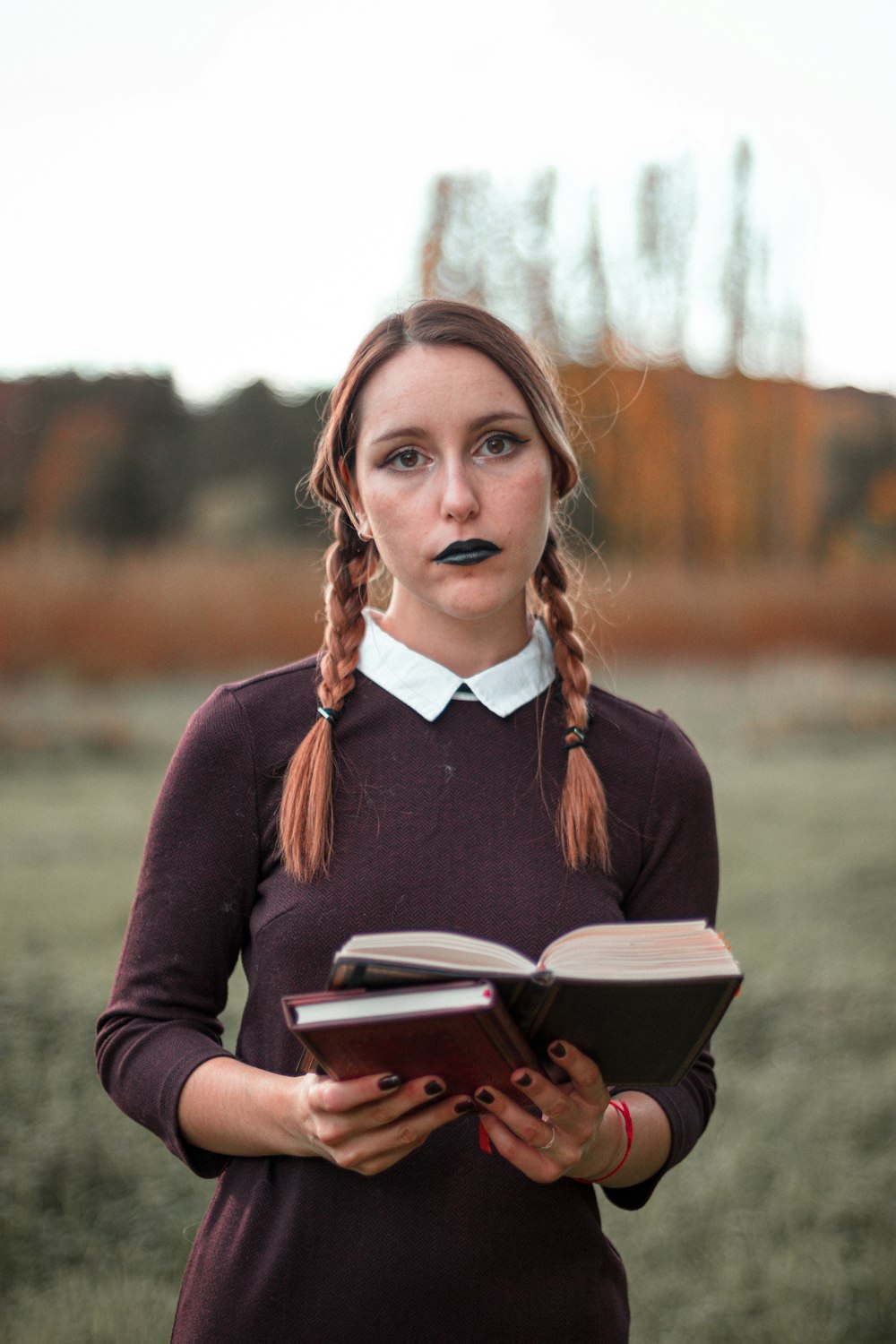 woman in purple long sleeve shirt holding book