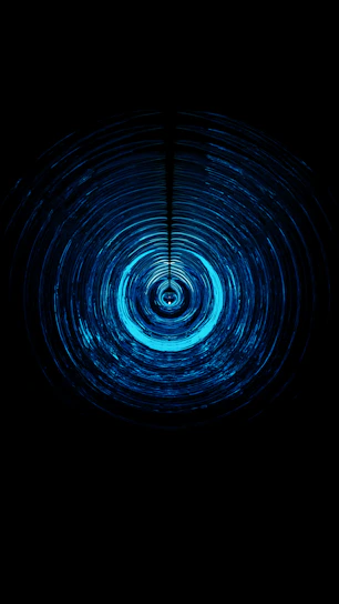 Close-up of a glowing ripple effect spreading across a button on a dark background.