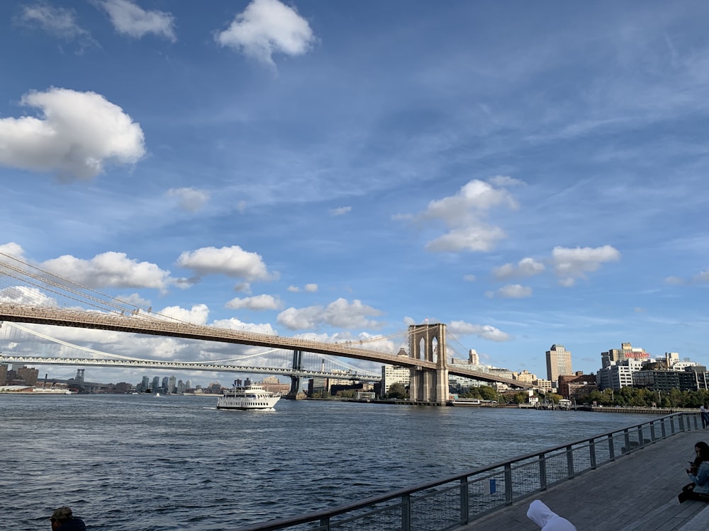 white and brown concrete bridge under blue sky and white clouds during daytime