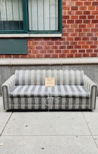 gray and brown couch beside brown brick wall