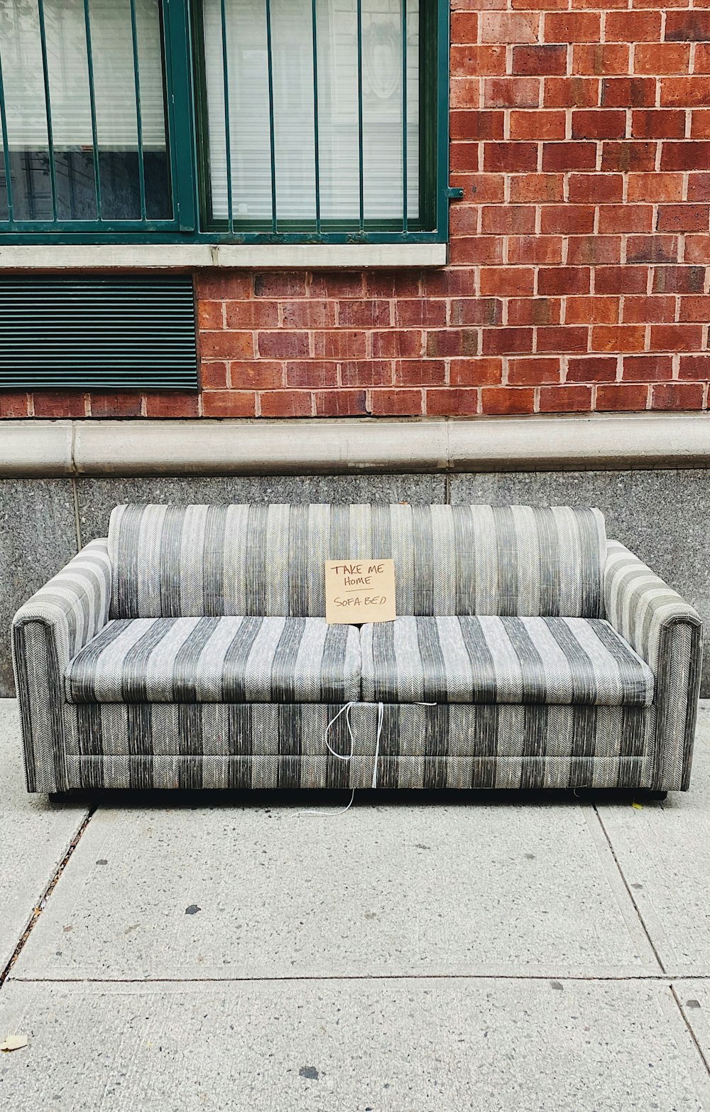 gray and brown couch beside brown brick wall