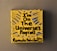 A small yellow canvas displays bold black text that reads 'I'm on the Universe's Payroll' with the artist's signature and date at the bottom. There are blue and gray radial lines emanating from the text, creating a dynamic visual effect.