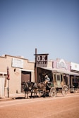 people riding horses in front of brown concrete building during daytime