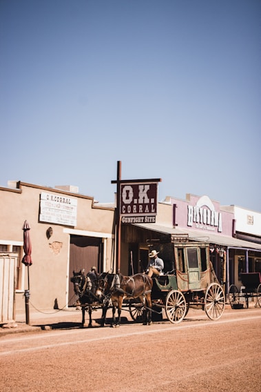 people riding horses in front of brown concrete building during daytime