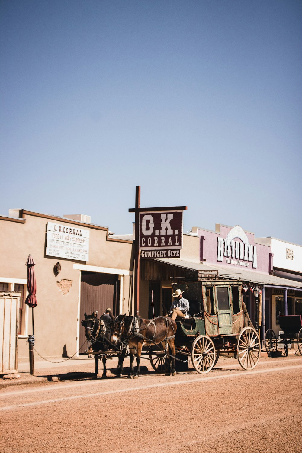 people riding horses in front of brown concrete building during daytime