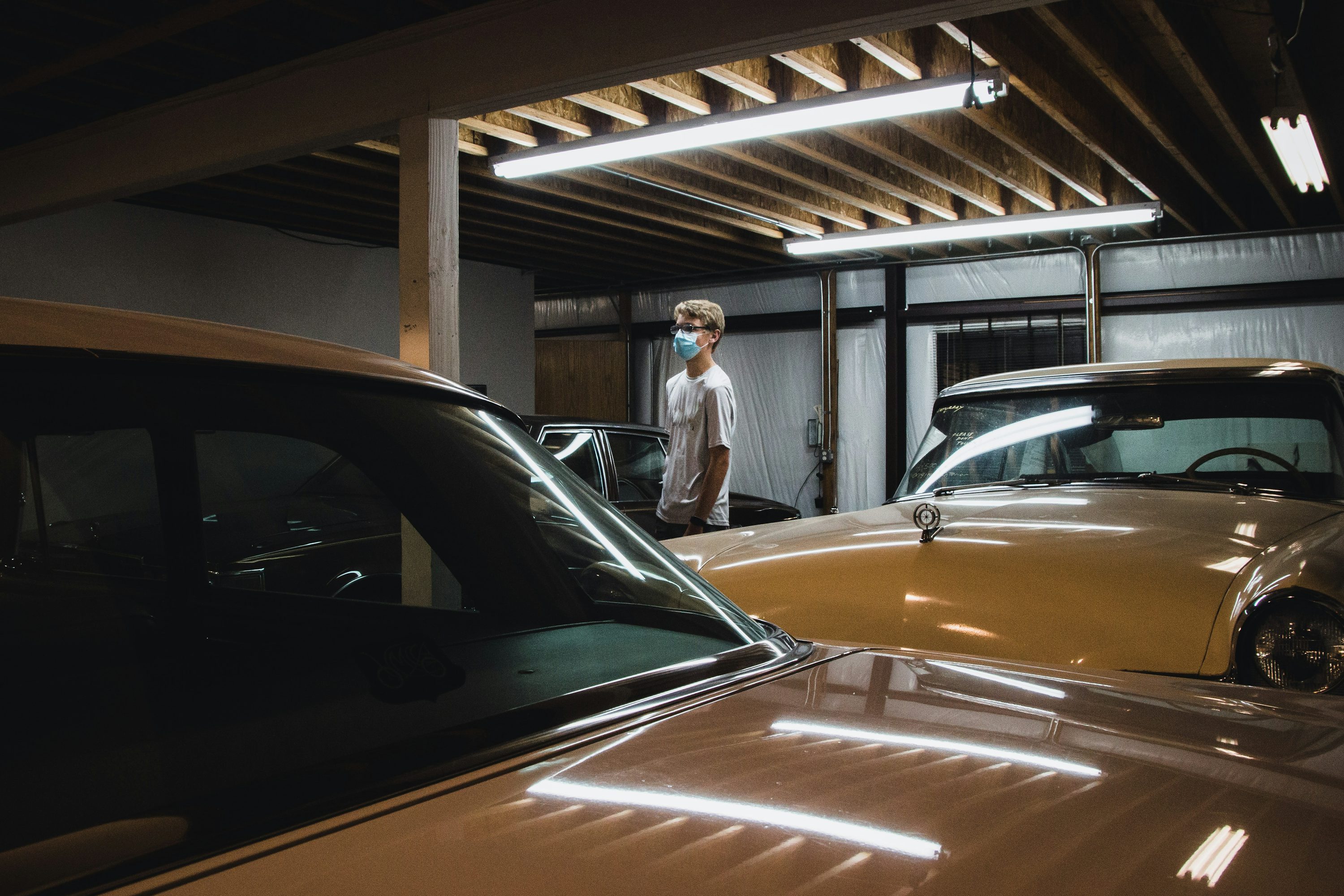 man in white dress shirt standing beside orange car during daytime