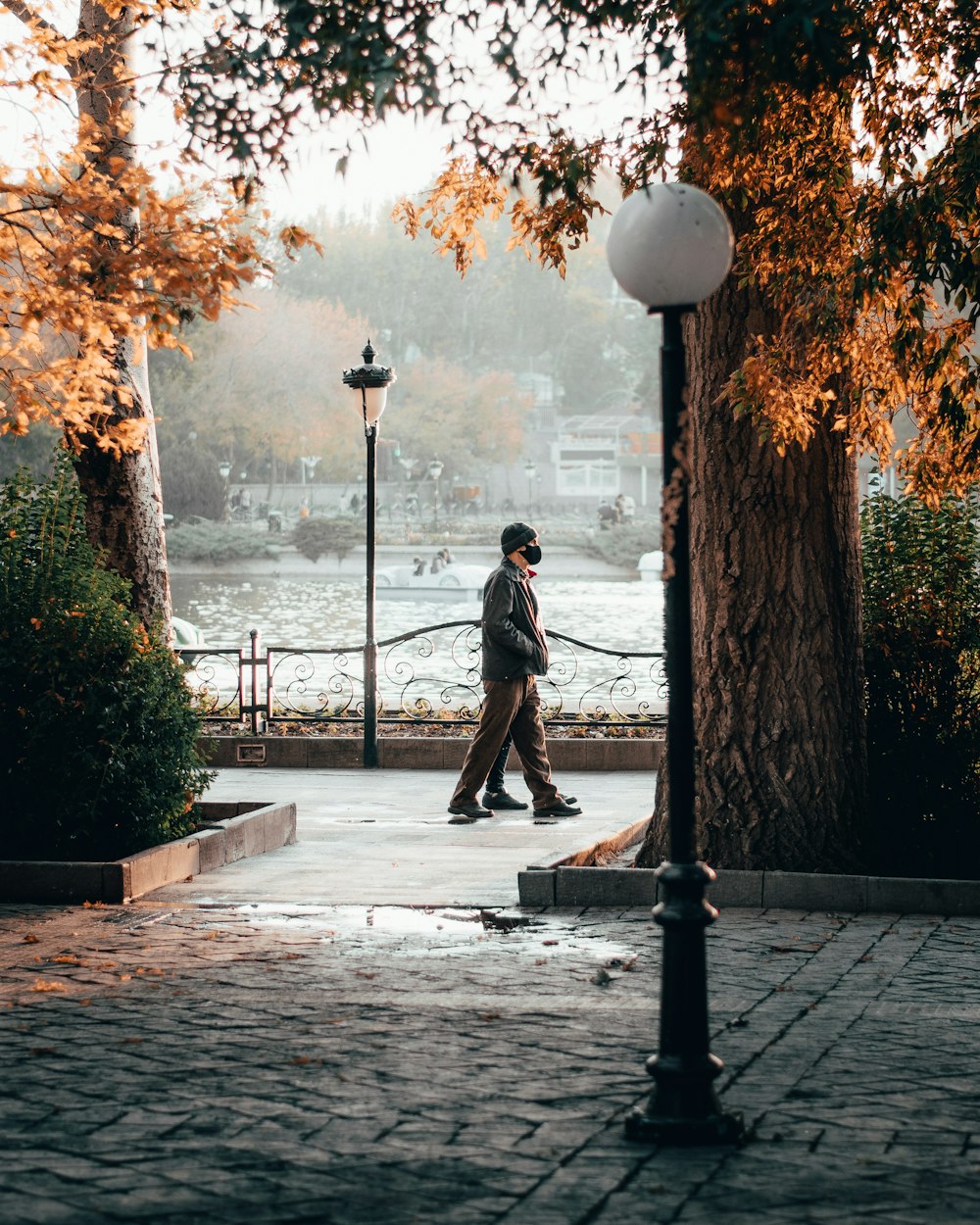 man in black jacket and pants standing on gray concrete floor during daytime