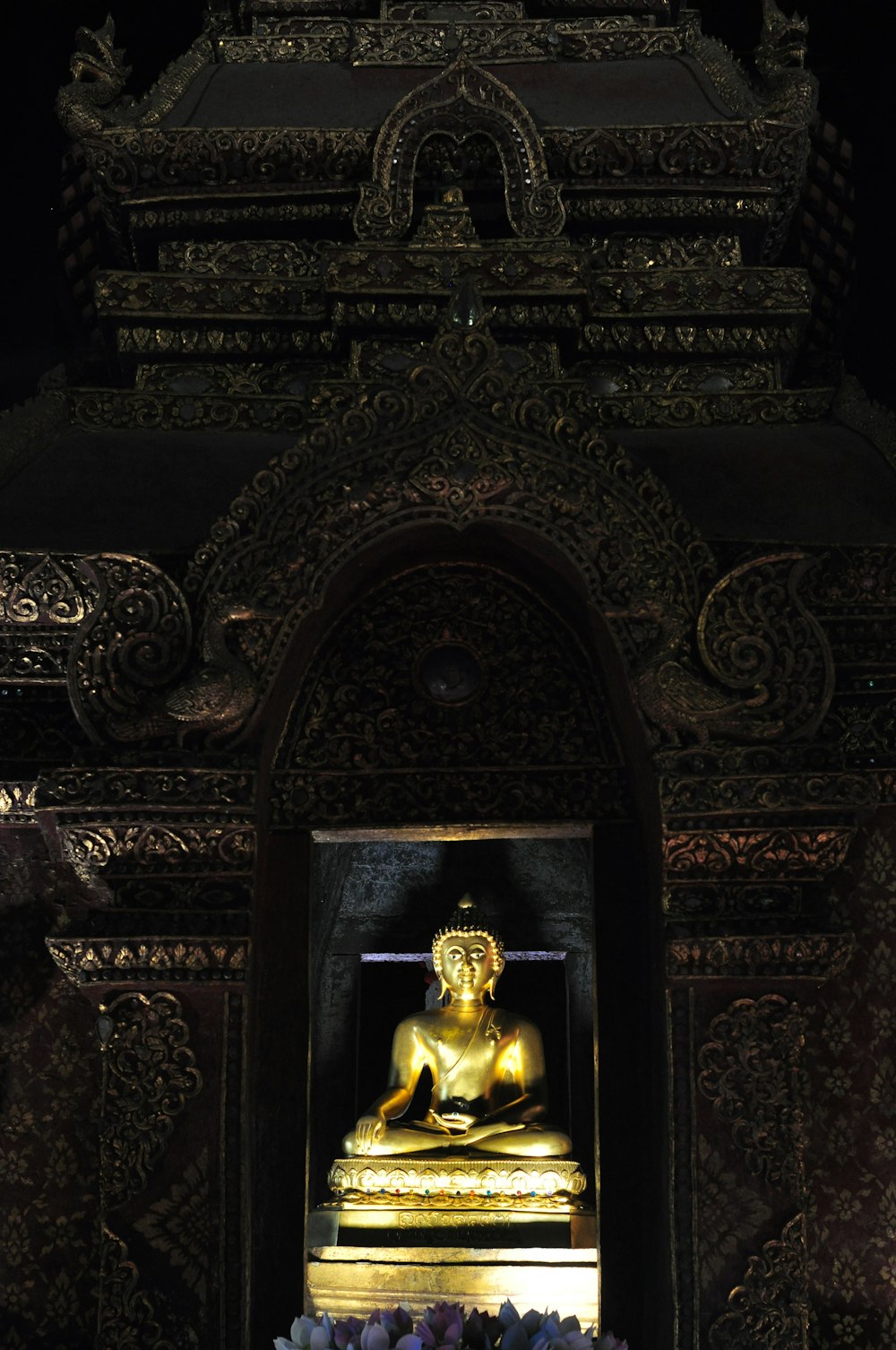 gold buddha statue on black and gold wall