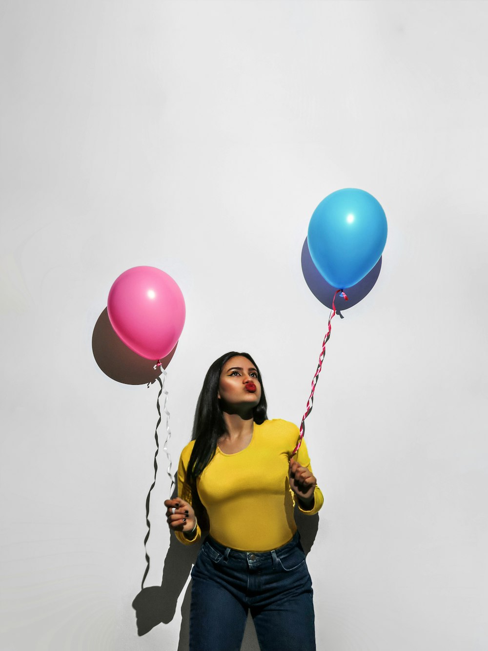 Frau im gelben Tanktop hält Luftballons