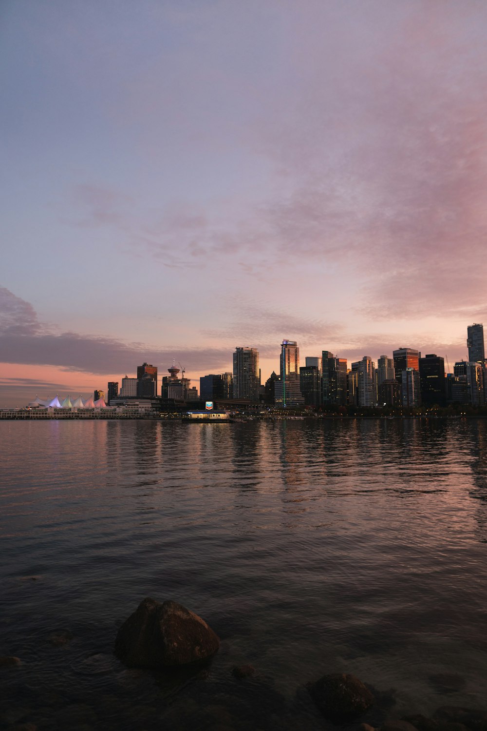 city skyline across body of water during sunset