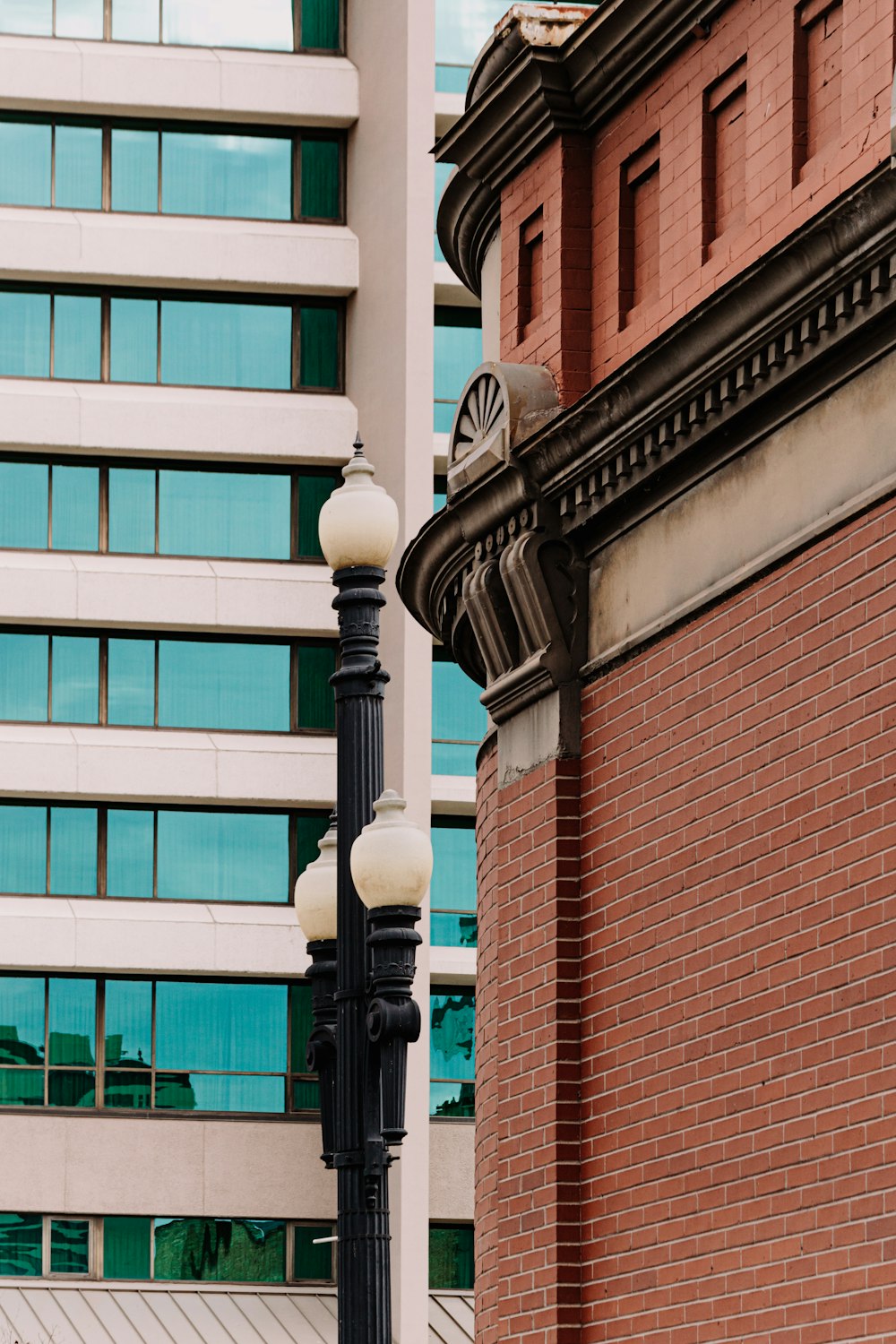 Farola negra cerca de un edificio de hormigón marrón y blanco durante el día