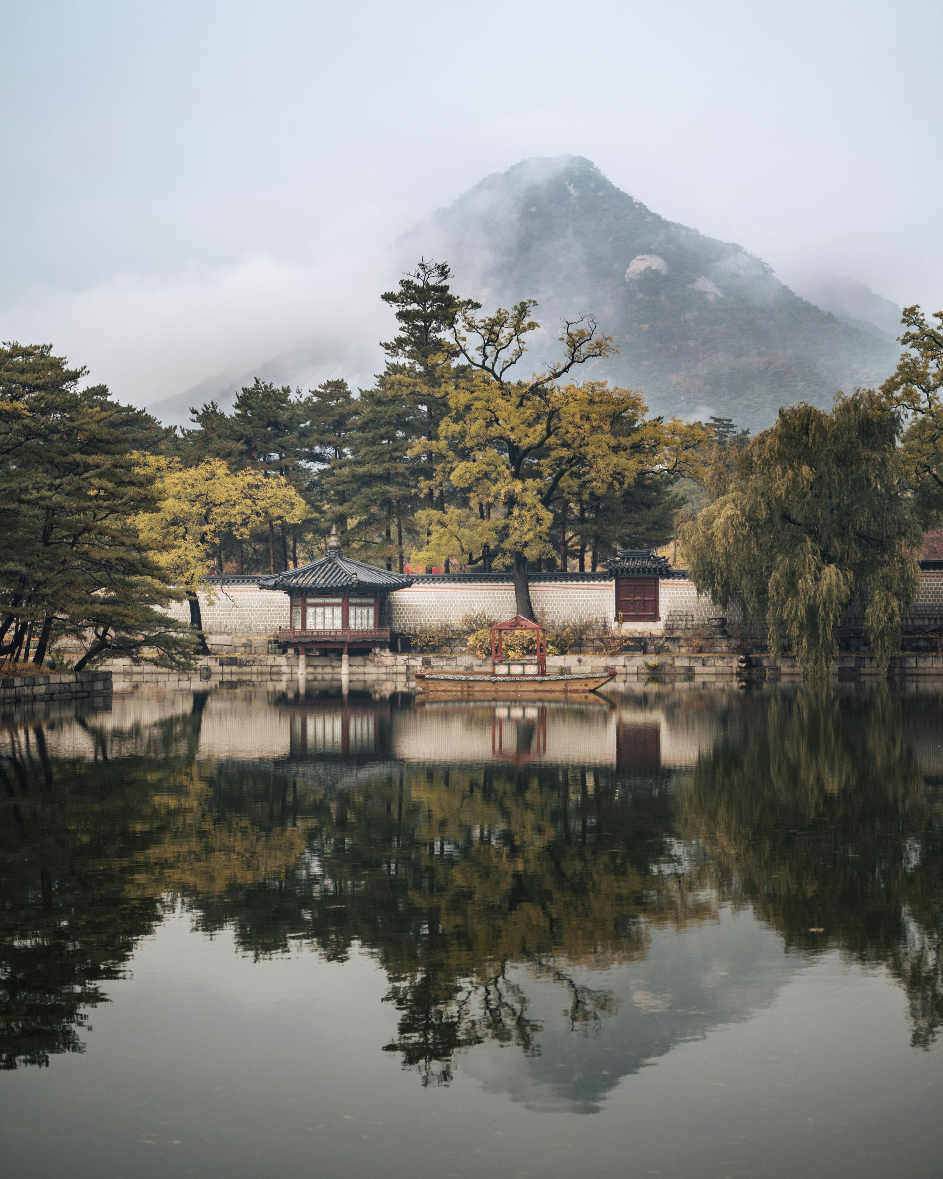 brown-and-white-house-near-green-trees-and-lake-during-daytime