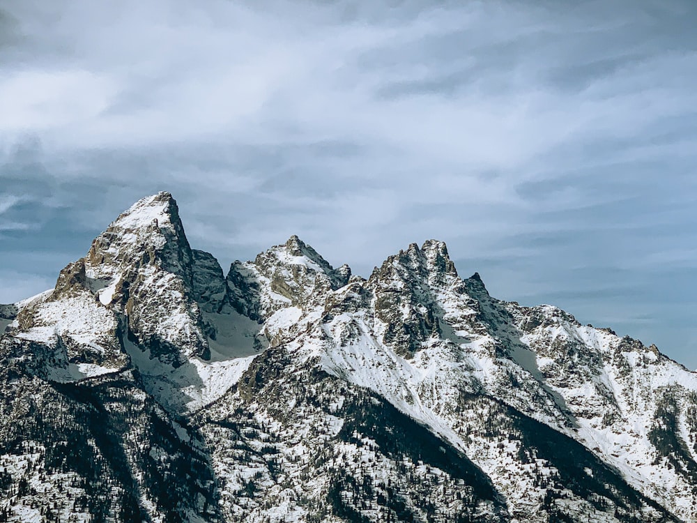 snow covered mountain under cloudy sky during daytime