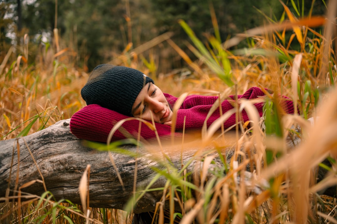 woman in red and white scarf lying on brown grass