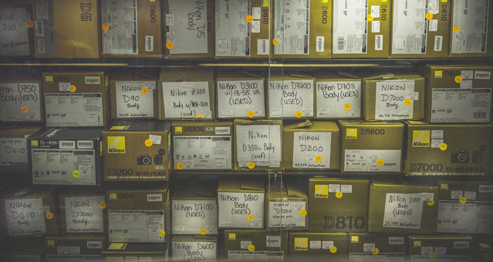 a wall full of boxes with yellow labels on them