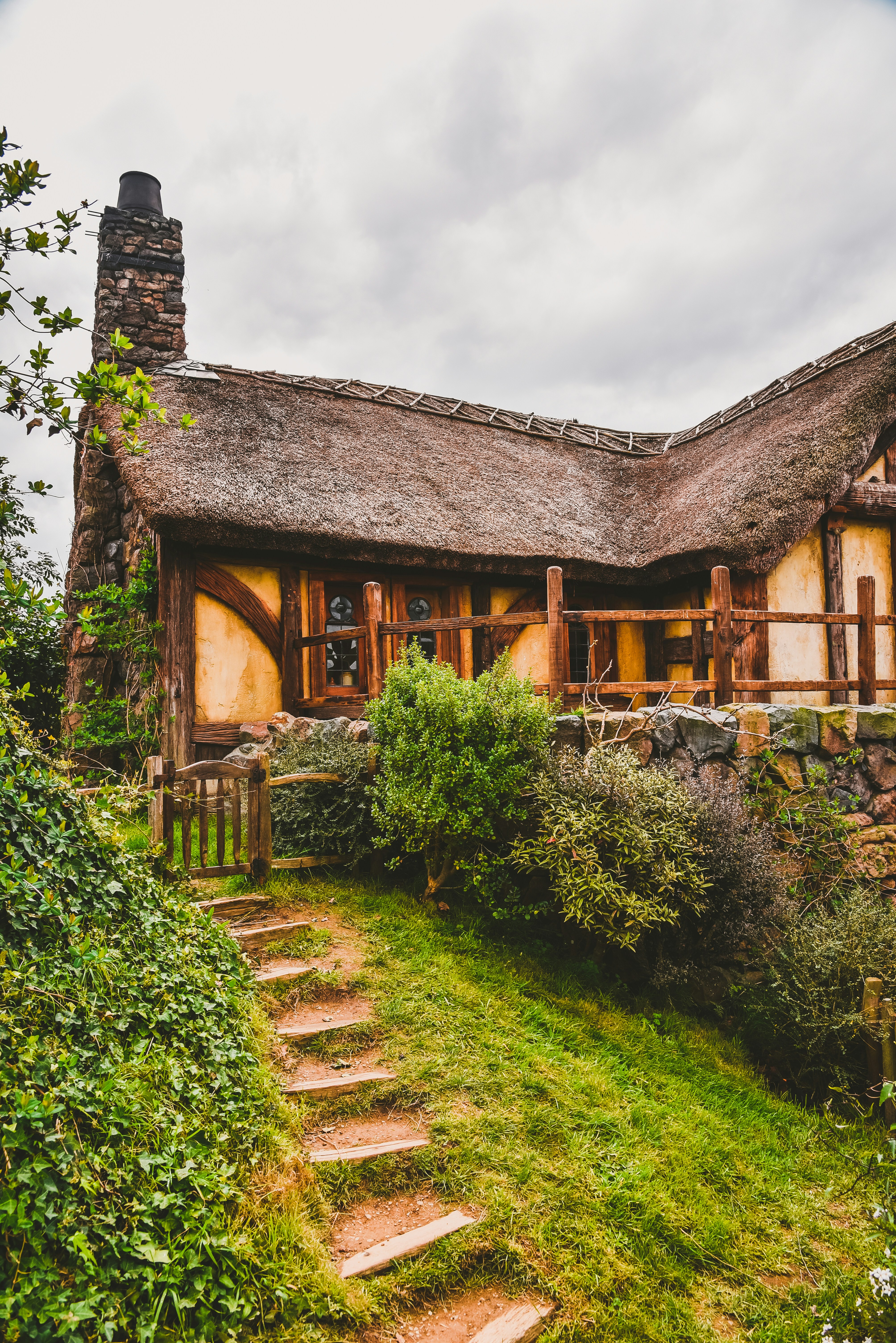 brown wooden house near green grass field during daytime