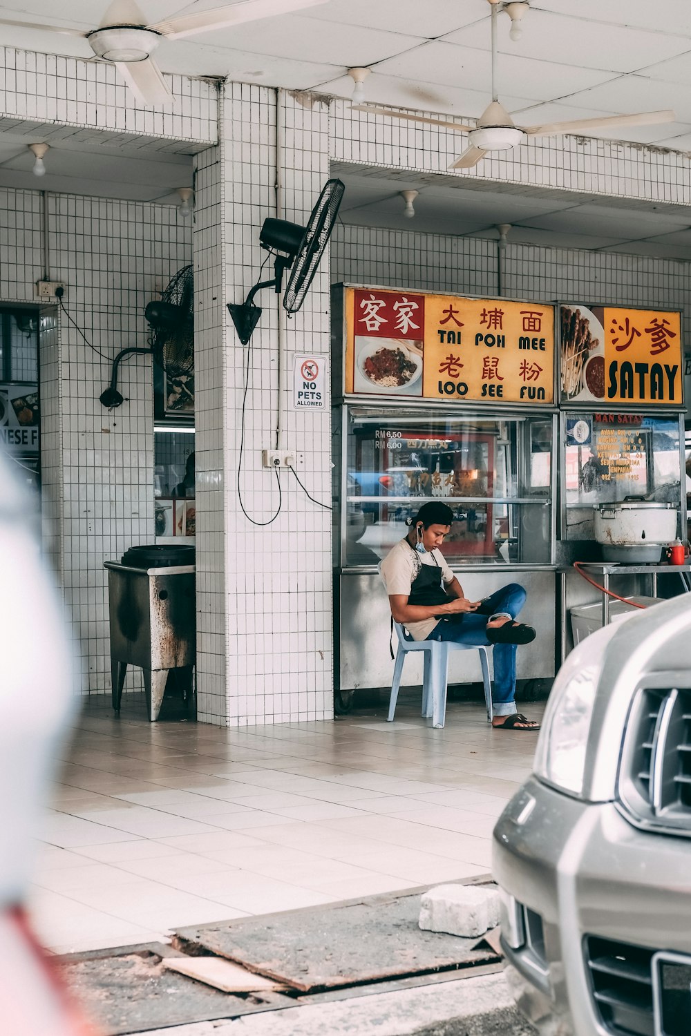 man in black t-shirt sitting on white plastic chair