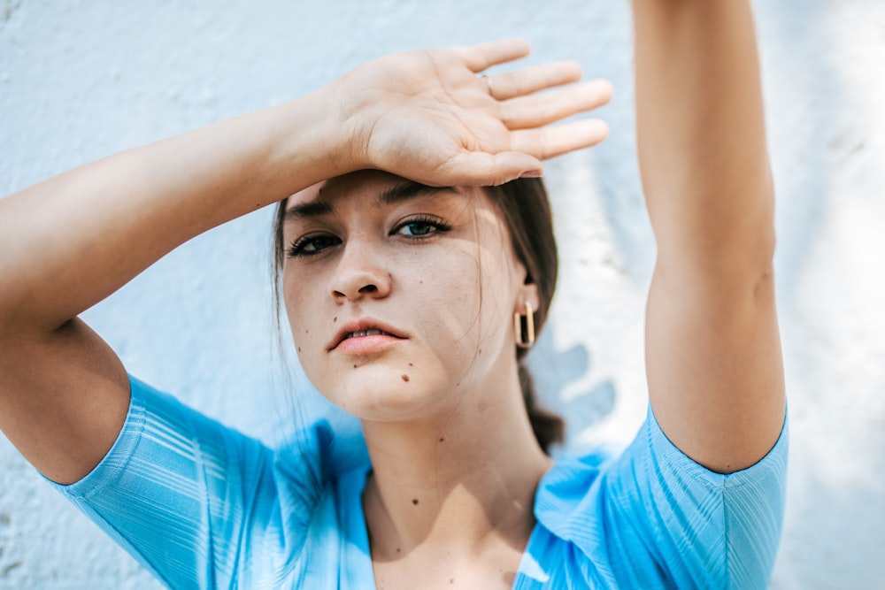 青いクルーネックシャツの女性