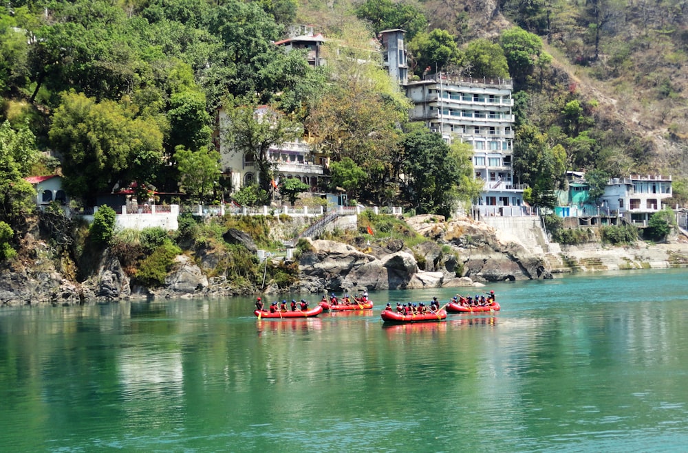 people riding red kayak on river during daytime