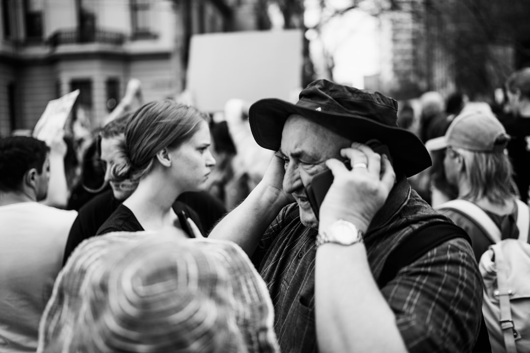 grayscale photo of man in hat and plaid shirt