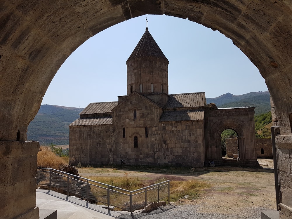 Bâtiment en béton brun près d’un champ d’herbe verte pendant la journée