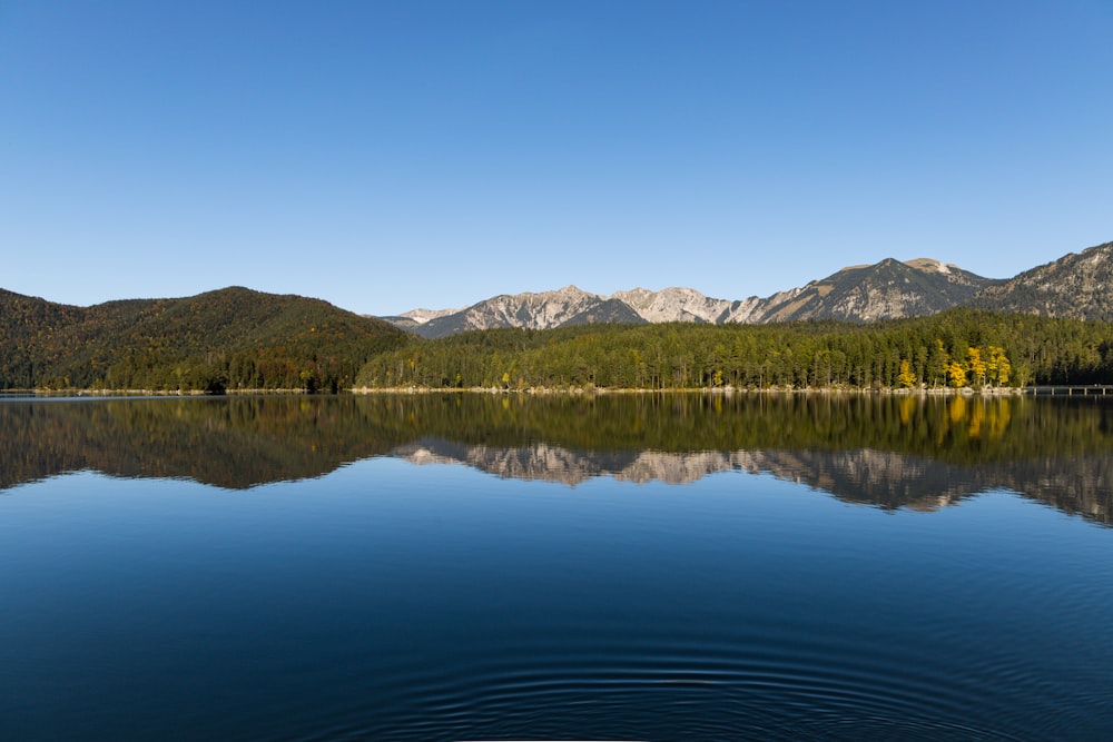 lake near mountain under blue sky during daytime