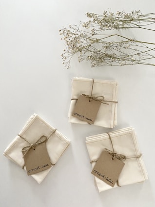 A close-up of soft, textured paper napkins stacked neatly on a wooden table, showcasing their fine quality.