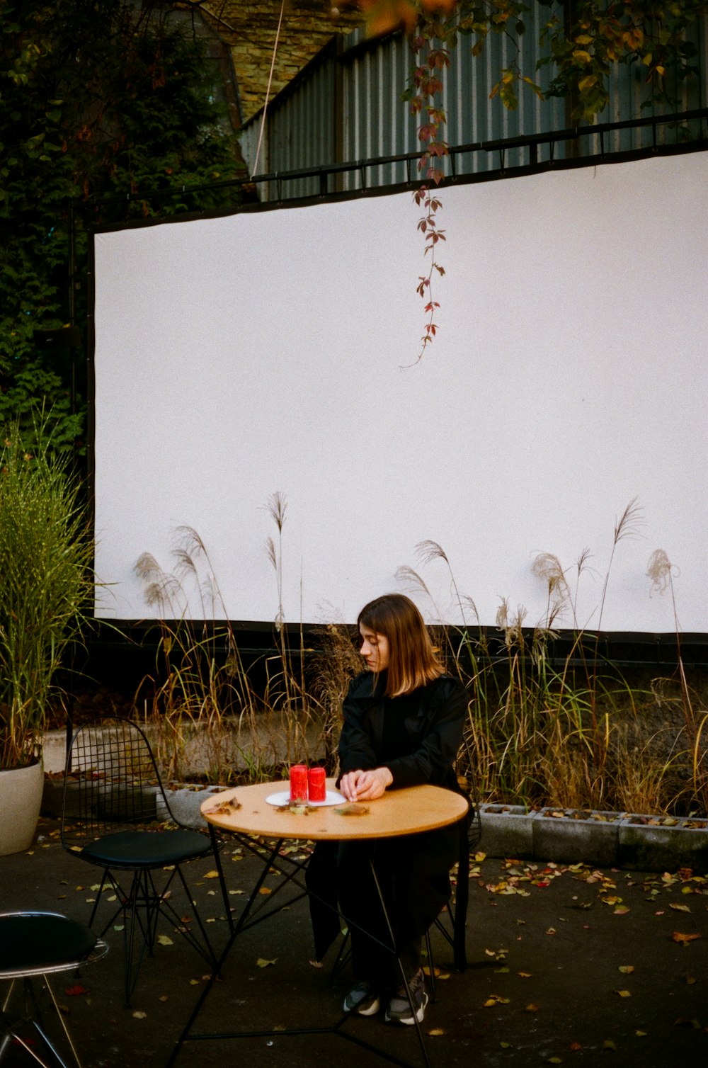 girl in black long sleeve shirt sitting on chair in front of table