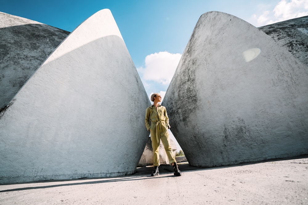 man and woman standing beside gray concrete wall during daytime