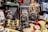 A collection of vintage cameras and binoculars is arranged among various antique items, including ornate gold-colored hand sculptures and an assortment of intricate objects. The cameras have a classical design with lenses and bellows, evoking a sense of nostalgia and historical interest.
