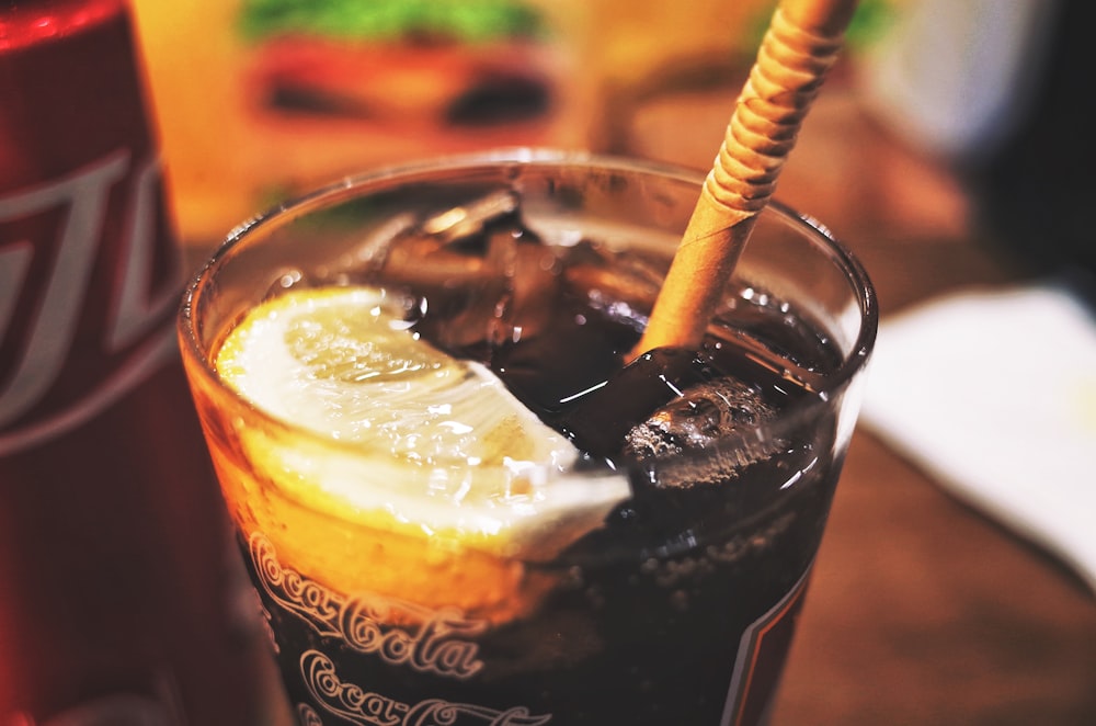 clear drinking glass with brown liquid and ice