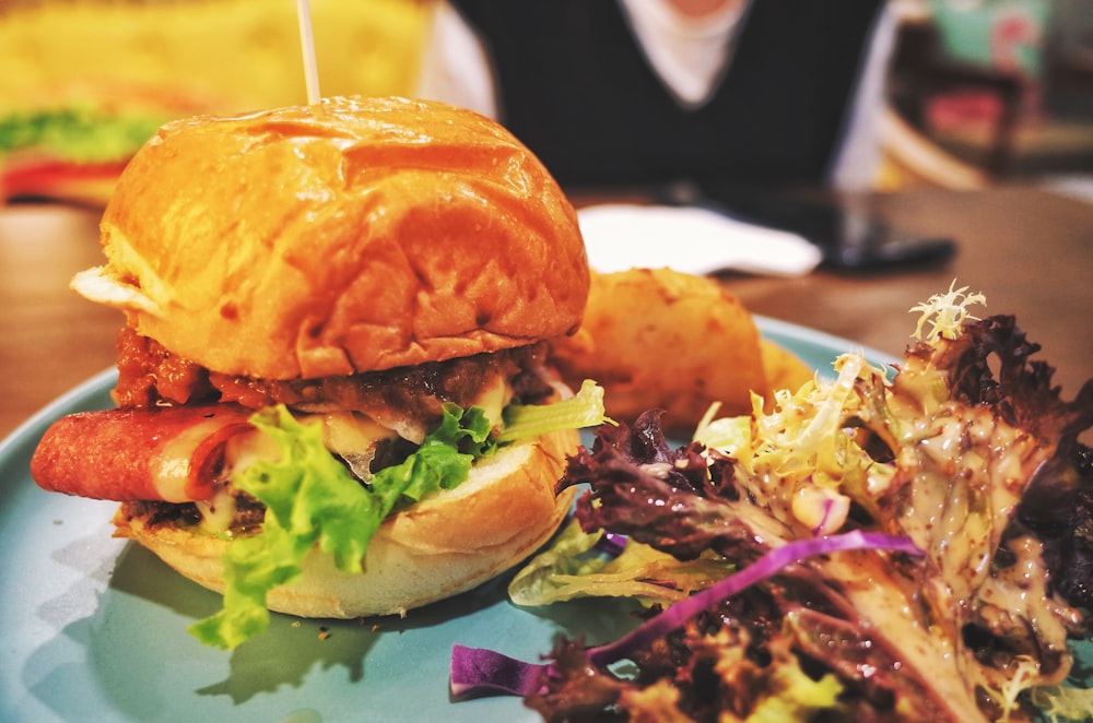 burger with lettuce and tomato on green plate