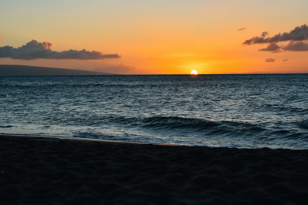 sea waves crashing on shore during sunset