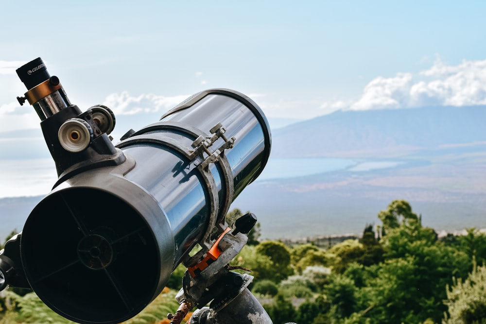 télescope noir et argent sur le champ d’herbe verte pendant la journée