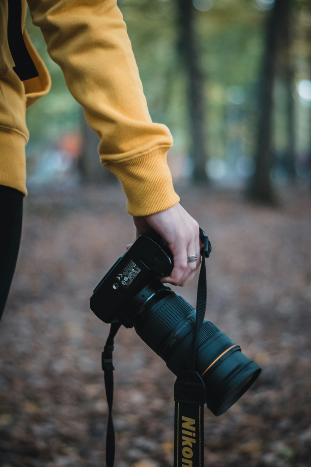 Persona sosteniendo una cámara DSLR Nikon negra