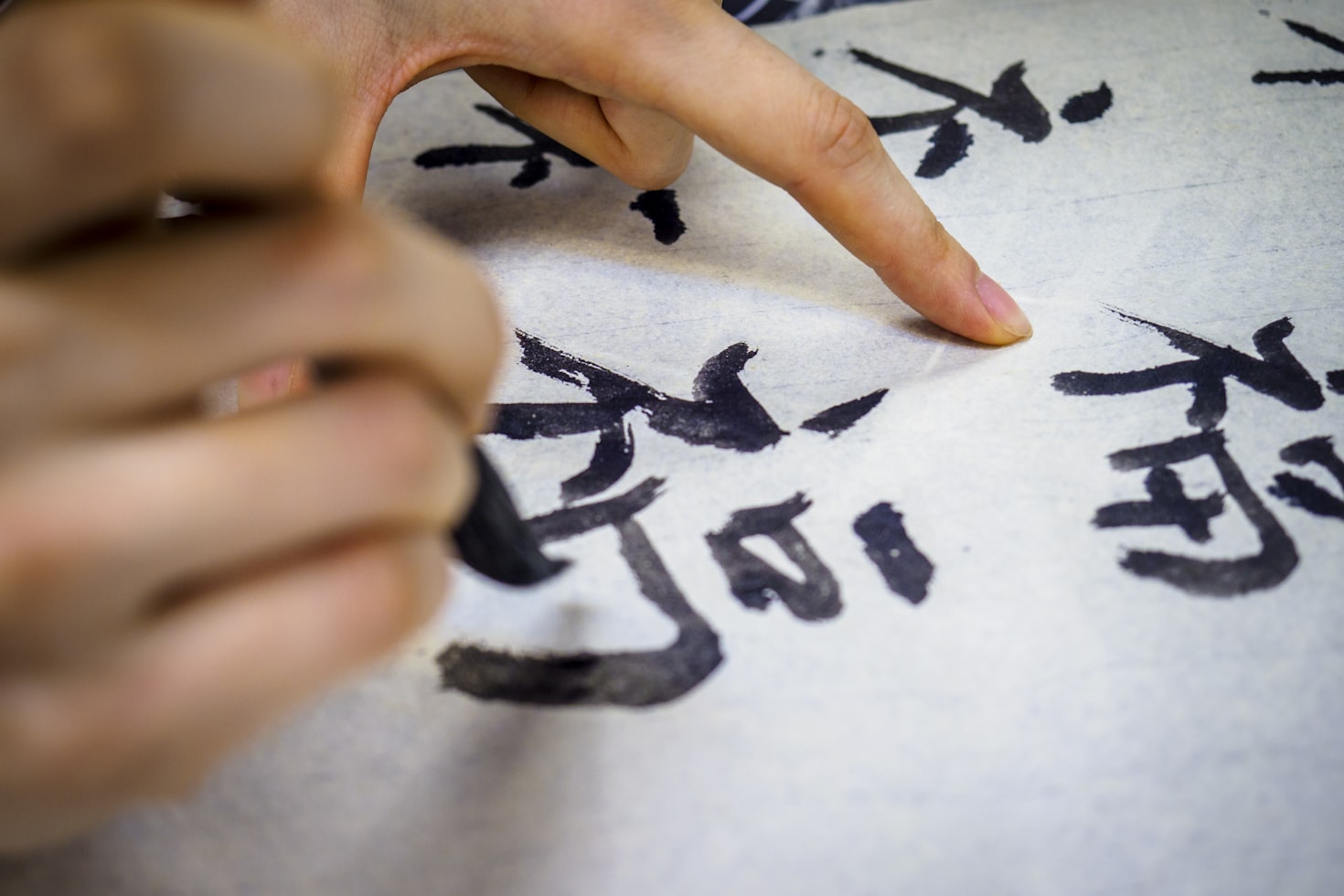 Someone writing Chinese calligraphy with a paint brush