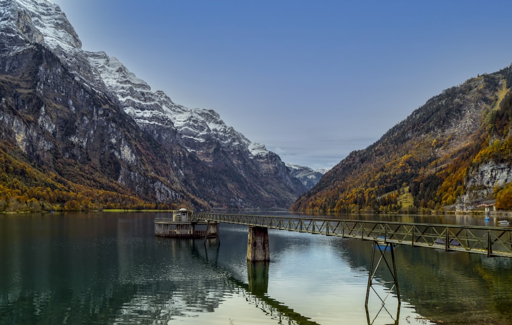 brown wooden dock on lake near mountain during daytime