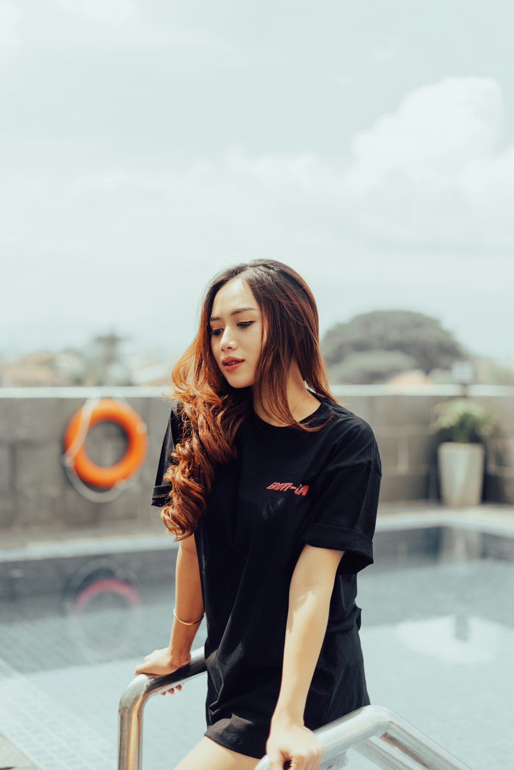 woman in black crew neck t-shirt standing on gray concrete floor during daytime