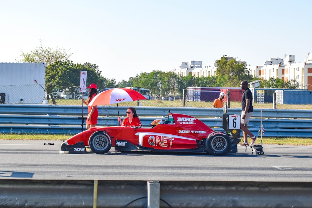 red and white f 1 car on road during daytime