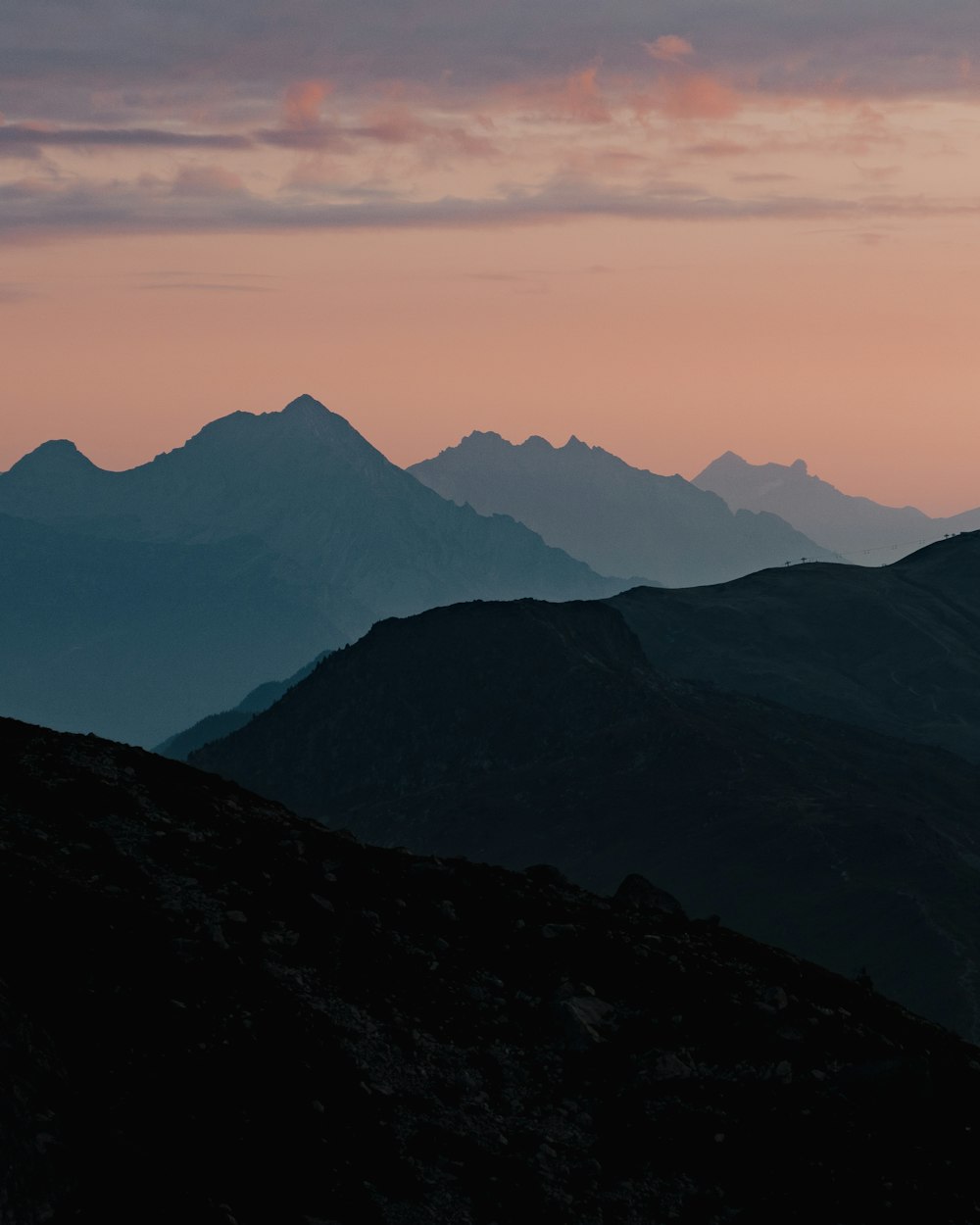 montagnes noires et blanches sous des nuages blancs pendant la journée