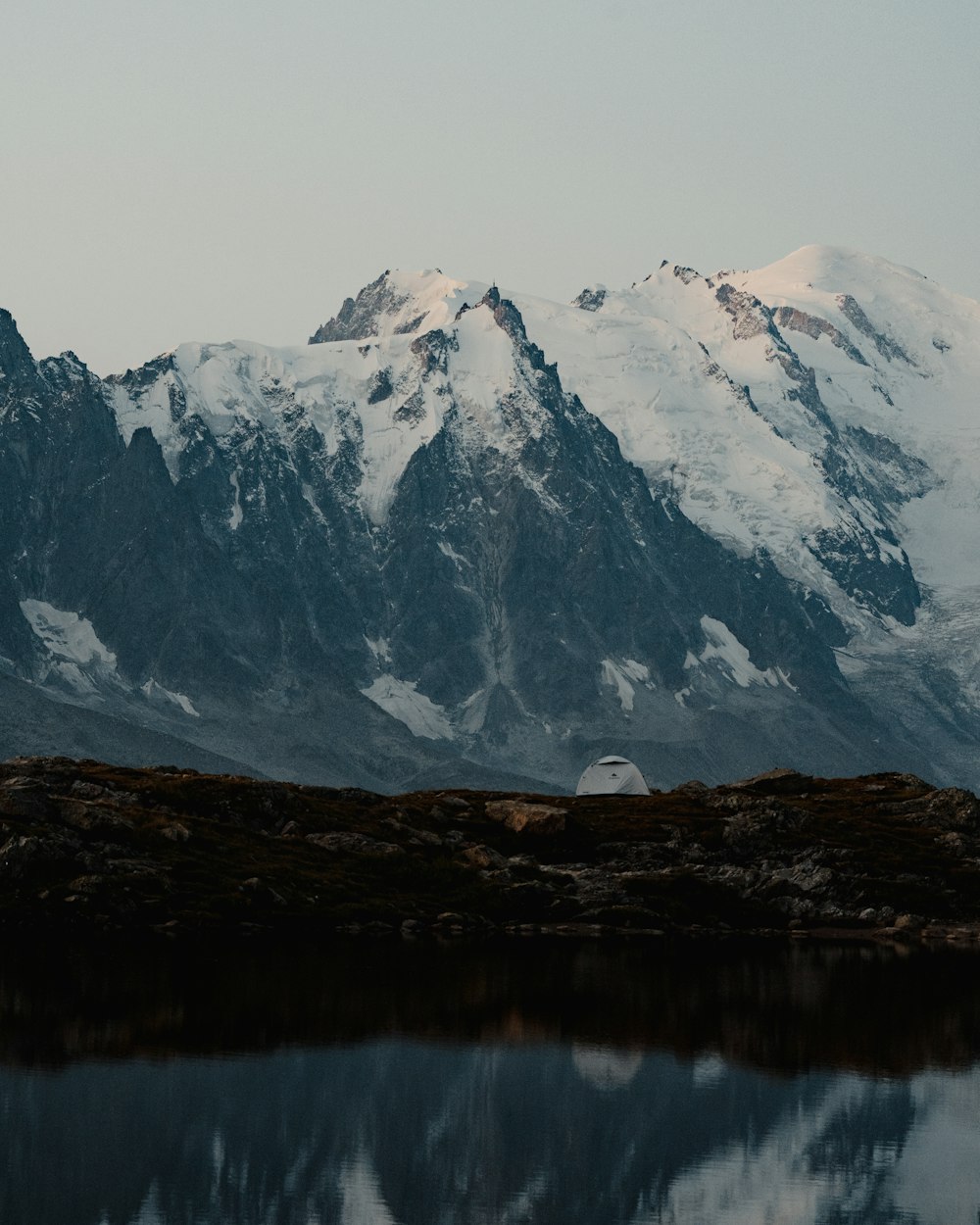 snow covered mountain near lake during daytime