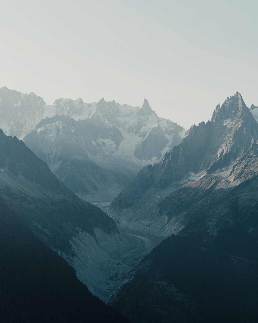 montagnes noires et blanches sous un ciel blanc pendant la journée