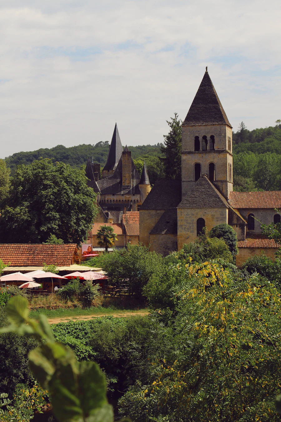 Muret et bâtiment en pierre bordés d'arbres