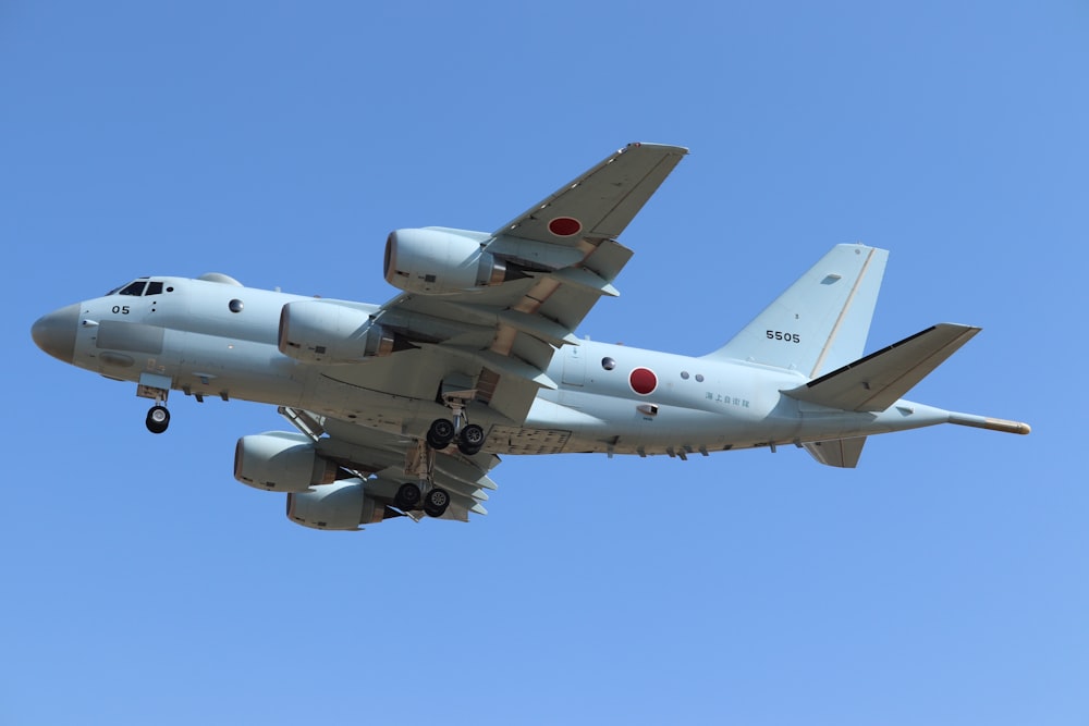 white jet plane in mid air during daytime