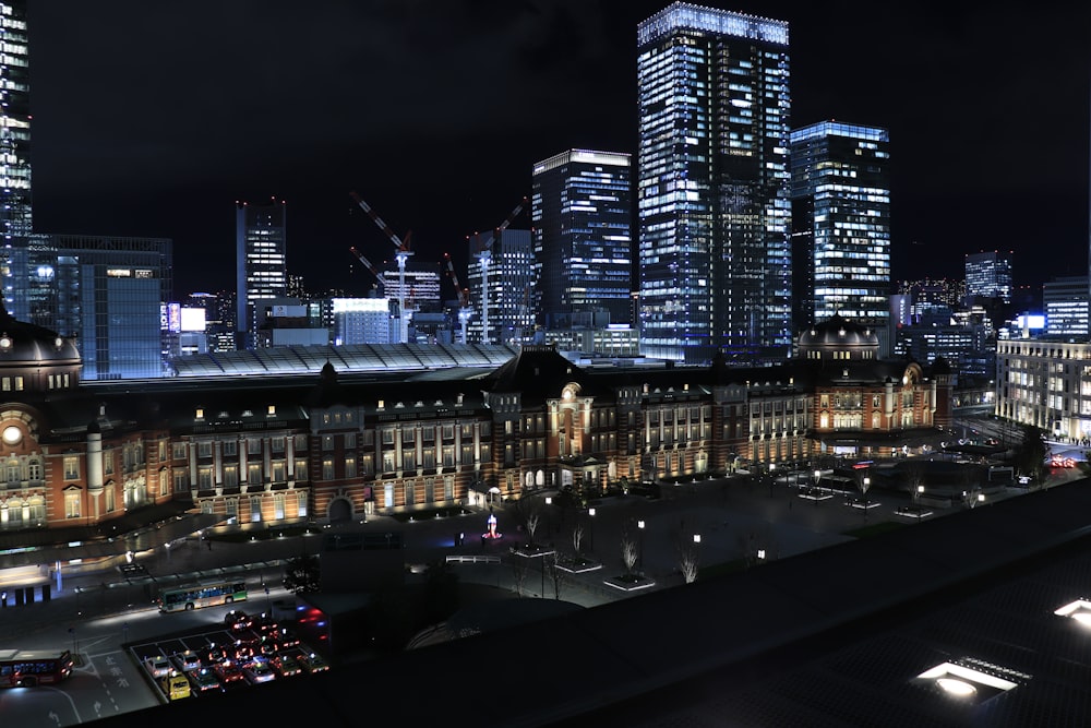 cars on road near high rise buildings during night time