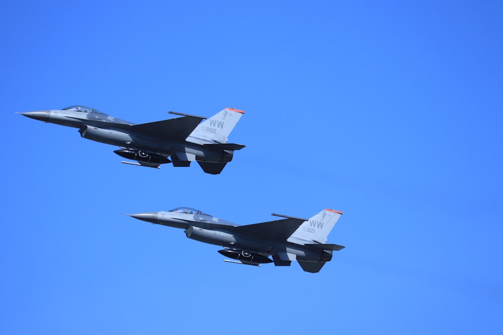 two fighter planes flying in the sky during daytime