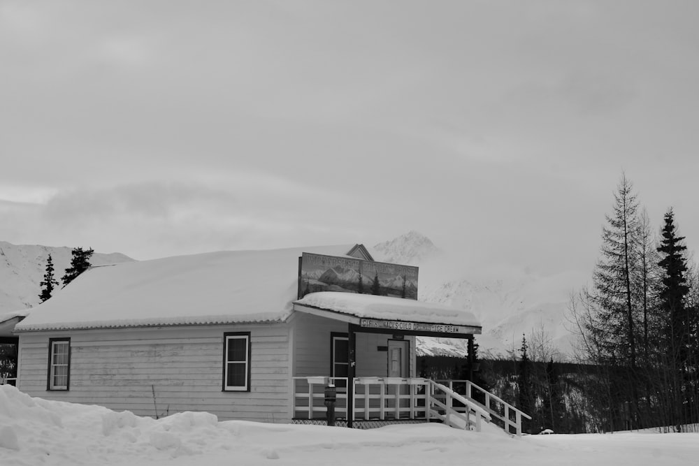 grayscale photo of house near trees