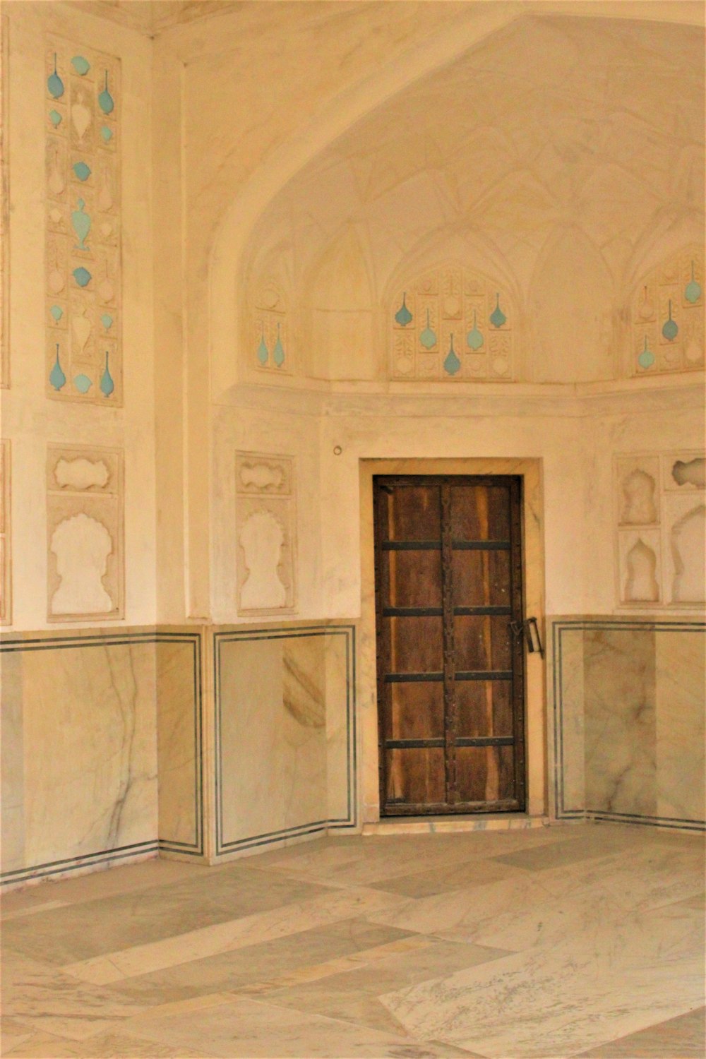 brown wooden door in white concrete building