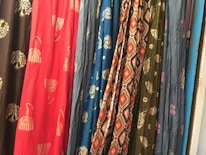 Close-up of colorful fabric textures laid out on a wooden table.